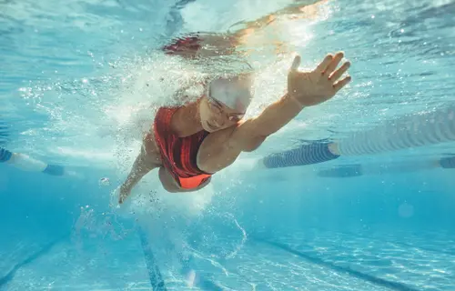 An image of a swimmer swimming through in a swimming pool.