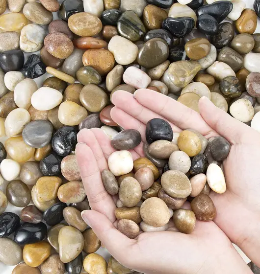 An image of two hands holding water filter pebbles.