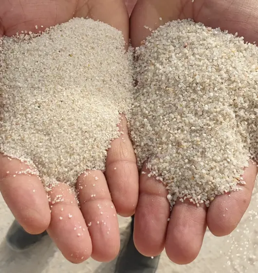 An image of two hands holding a handful of silica sand which is used for water filtration.